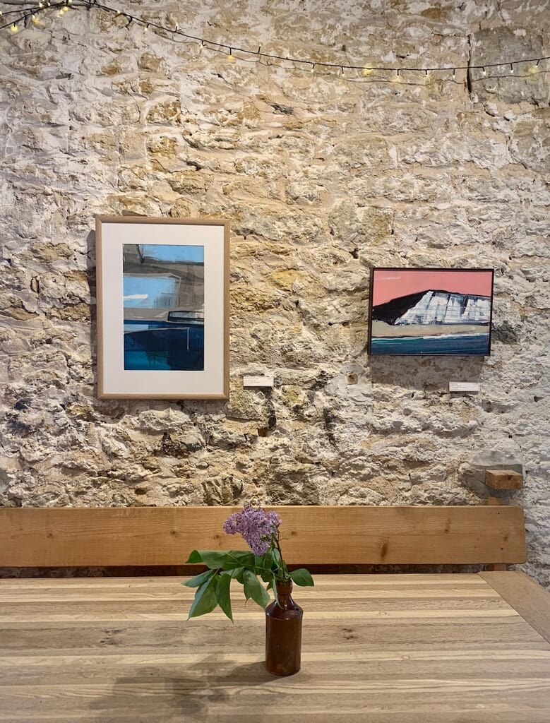 things to do in West Bay, Dorset - cafe at salder's yard inside table and art things to do in West Bay, Dorset - cafe at salder's yard inside table and art
