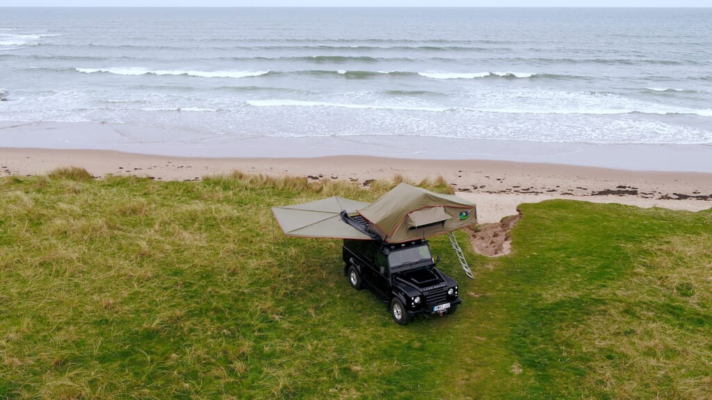 landrover defender camping tent set-up next to beach