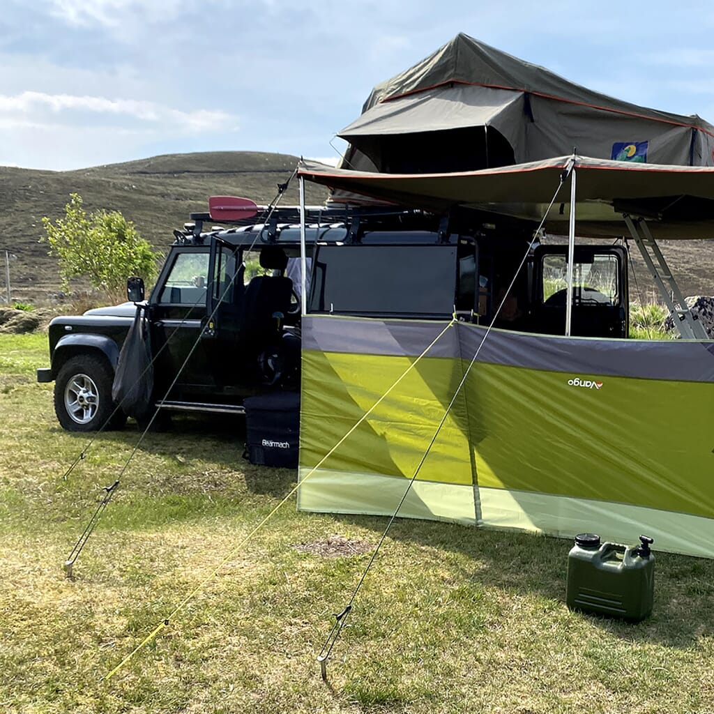landrover defender camping set up with wind break