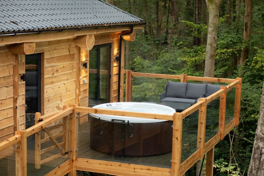 woodland park lodges dog-friendly treehouses: exterior with hot tub on deck